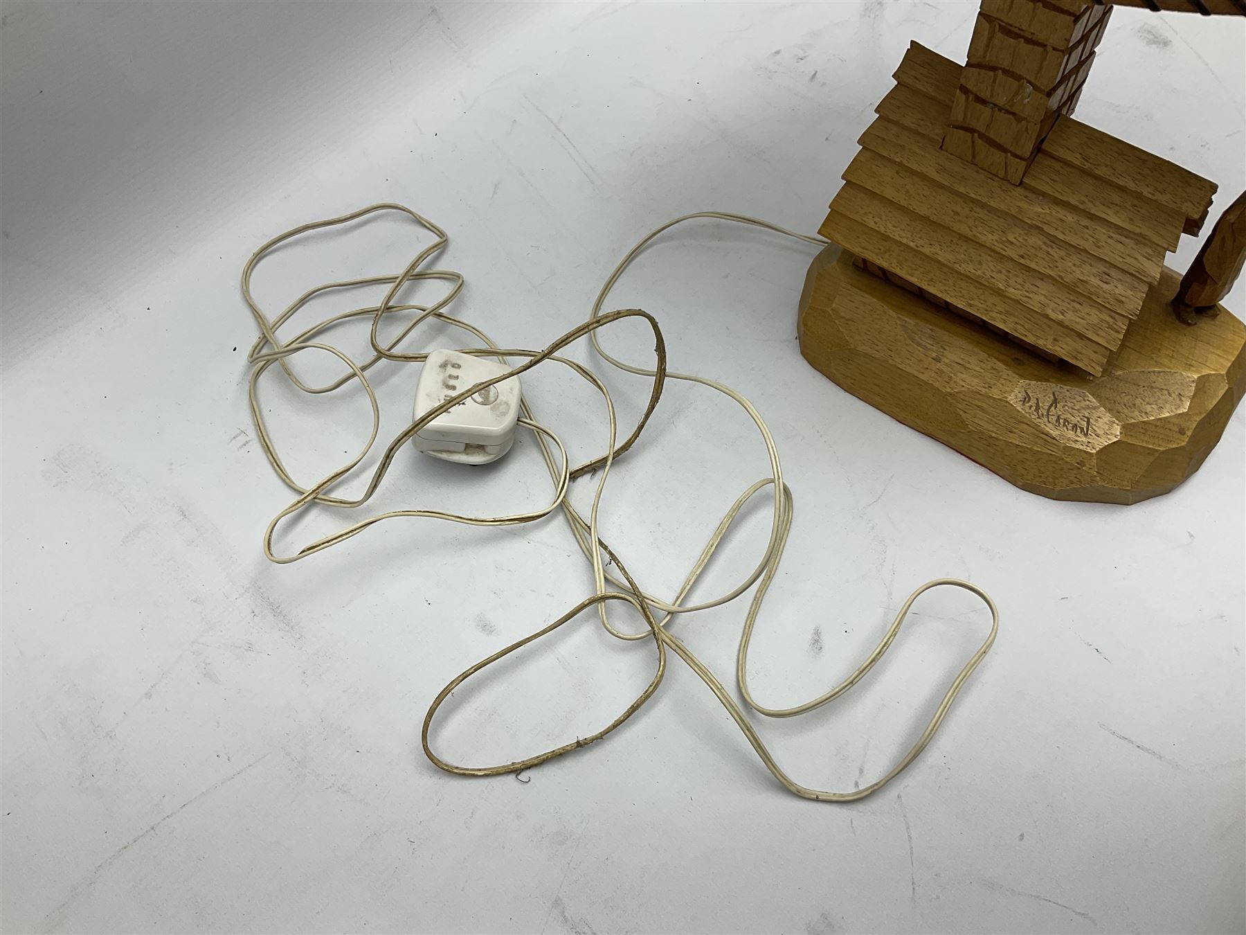 Mid 20th century Paul Caron carved table lamp, modelled as man standing before an oven, the chimney supporting the panelled shade, the base signed P.E. Caron, H42cm