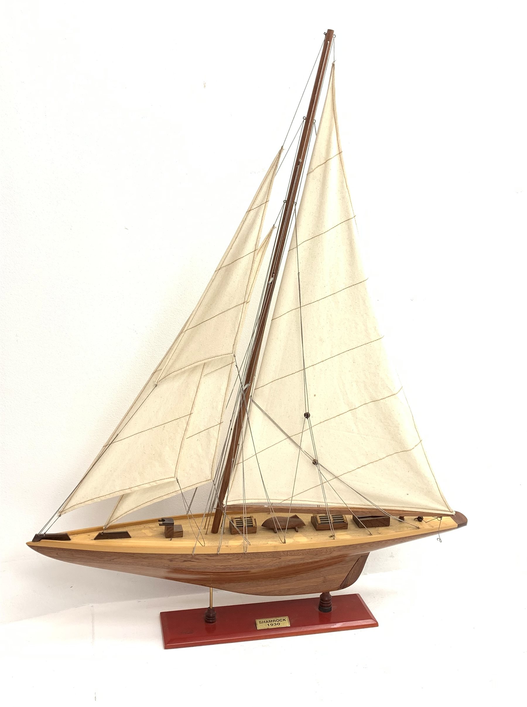Bespoke Oak Furniture model of a 1930s J Class Americas Cup Challenger sailing yacht with mahogany hull, simulated planked deck with various fittings and three sails, on integral stand with plaque 'Shamrock 1930', L80cm H101cm