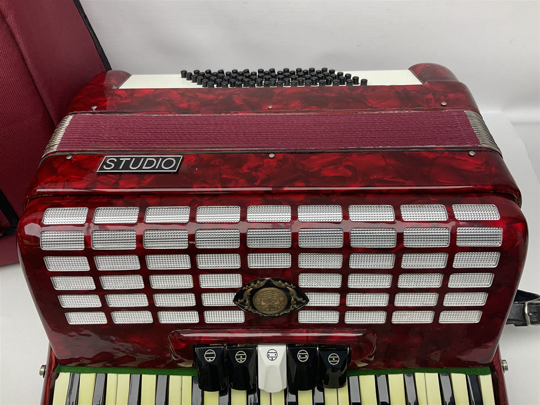 Hsinghai Studio piano accordion with red pearline finish, twenty keys and seventy-two buttons W44cm; in hard carrying case with additional The Music Room soft gig case