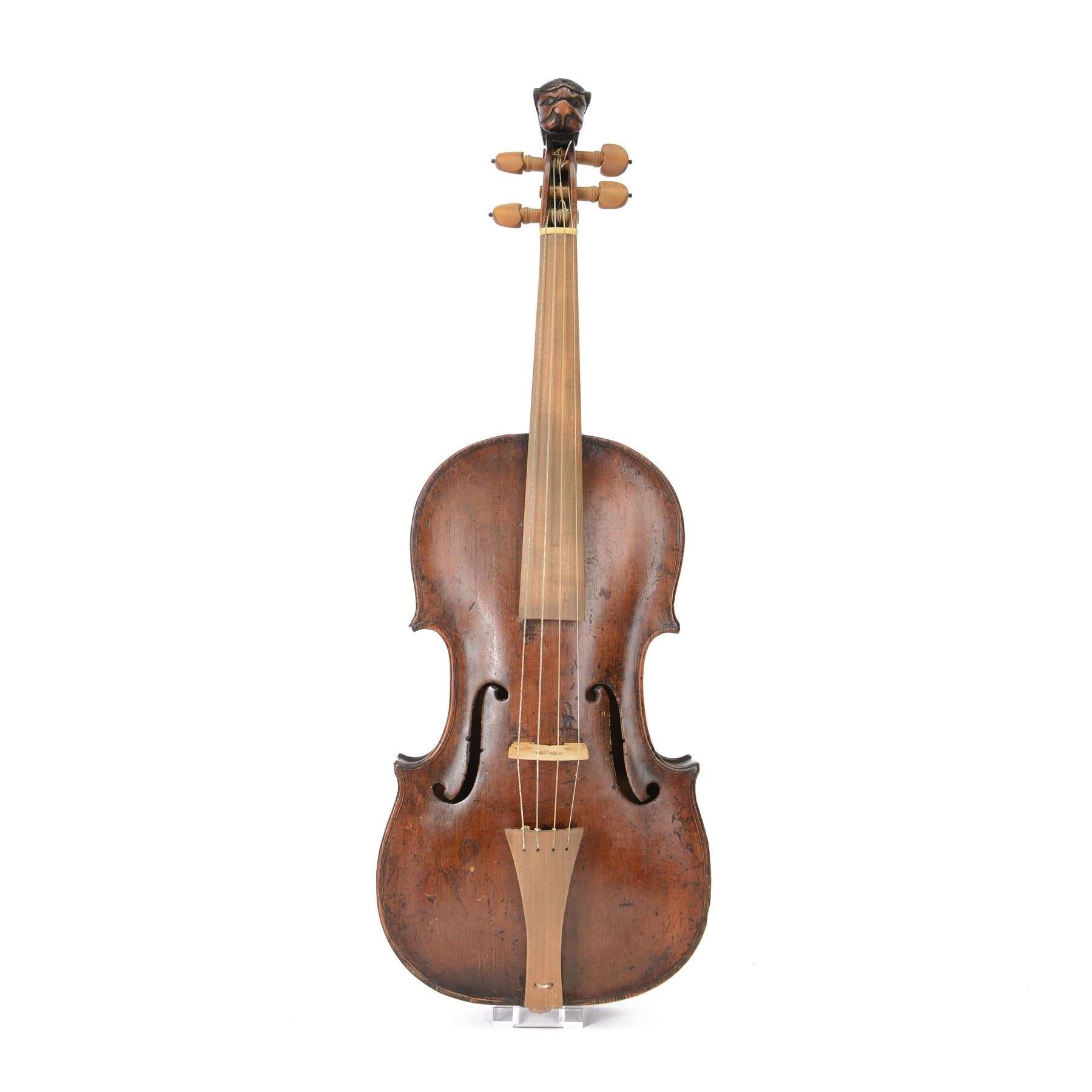 Violin - with a carved Lions head scroll and period style replacement fingerboard and fittings, in a later hard case, no bow, possibly from Germany or Bohemia.
Thought to have originated in the Tyrol region between Austria and Germany this design of scroll was very popular from the late 17th century onwards and well into the 19th century.