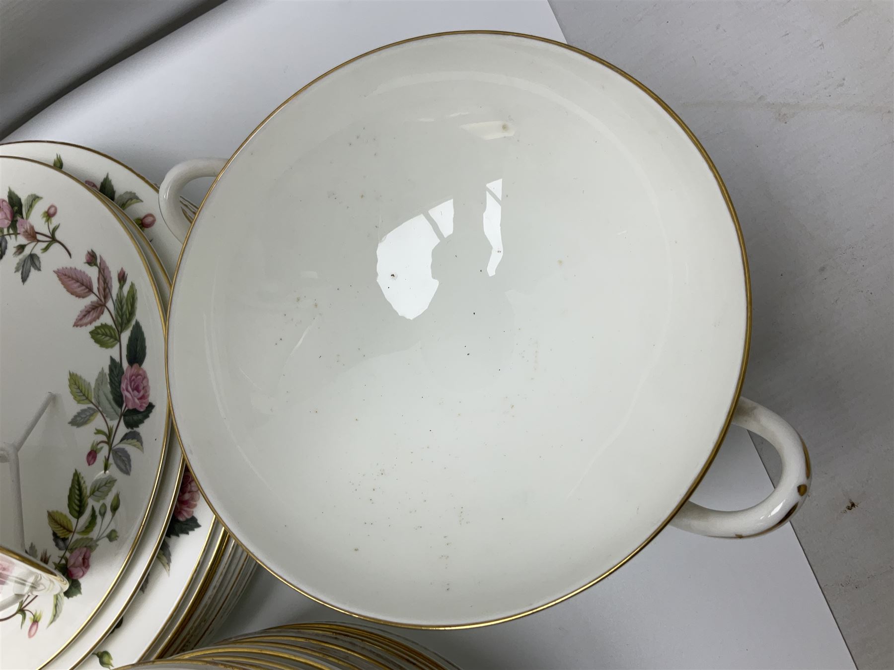Wedgwood Hathaway Rose pattern tea and dinner wares, comprising twelve saucers, sixteen teacups, twenty tea plates, jug, sucrier, thirteen shallow bowls, sauce boat and saucer, two lidded tureens, larger jug, ten dinner plates, nine smaller plates and two large oval serving dishes