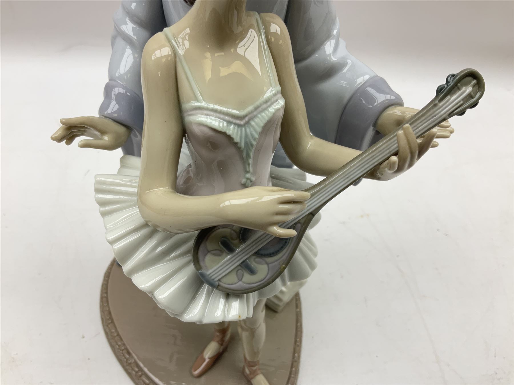 Lladro figure, Minstrel's Love, modelled as a couple entertaining, the lady in ballerina costume playing the lute and the gent stood behind her in jester type dress, sculpted by Rafael Lozano, with original box, no 5821, year issued 1991, year retired 1993, H31cm
