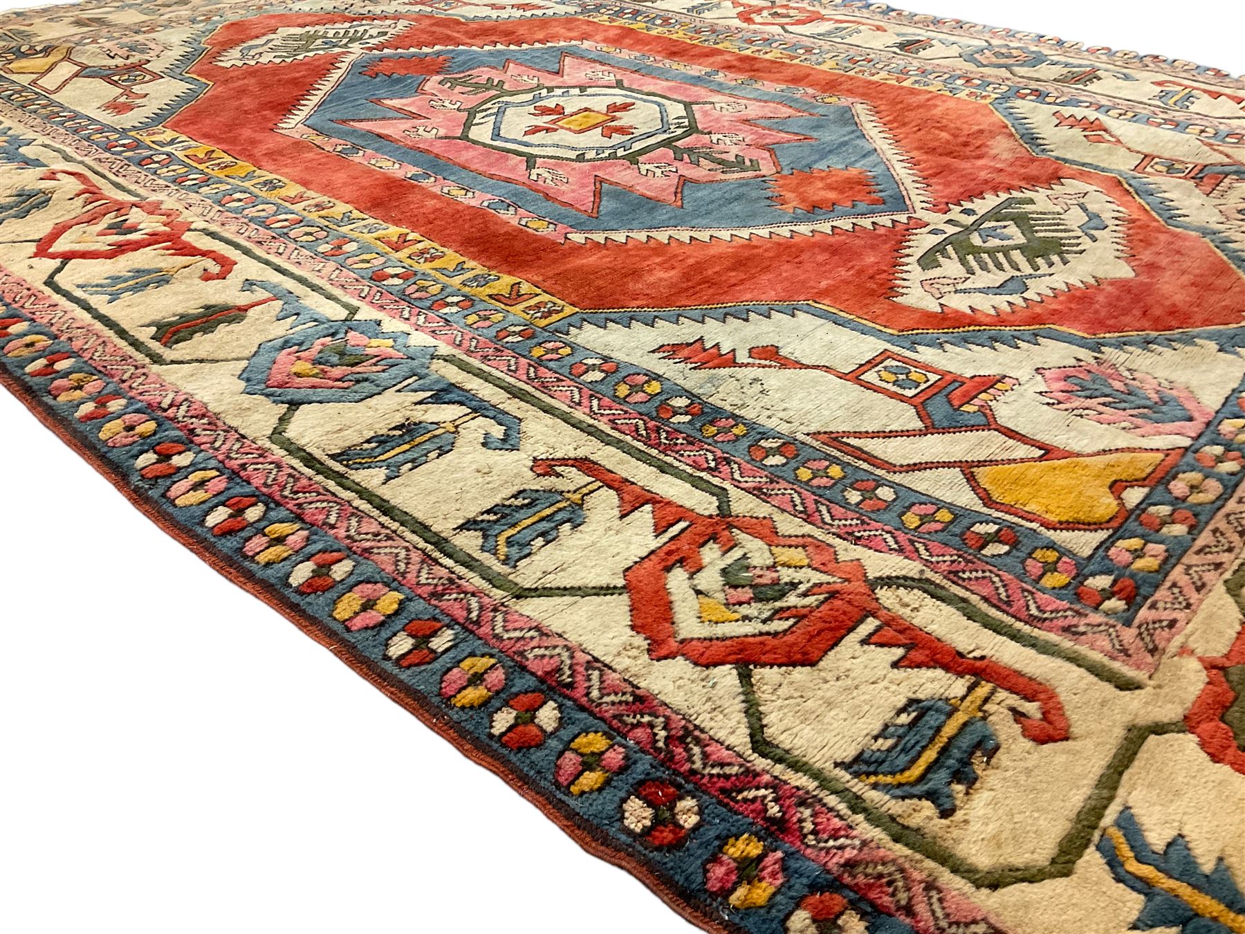 Anatolian Turkish ivory ground carpet, the central geometric pole medallion within an amber field, the guarded border decorated with stylised plant motifs surrounded by bands of repeating flower heads