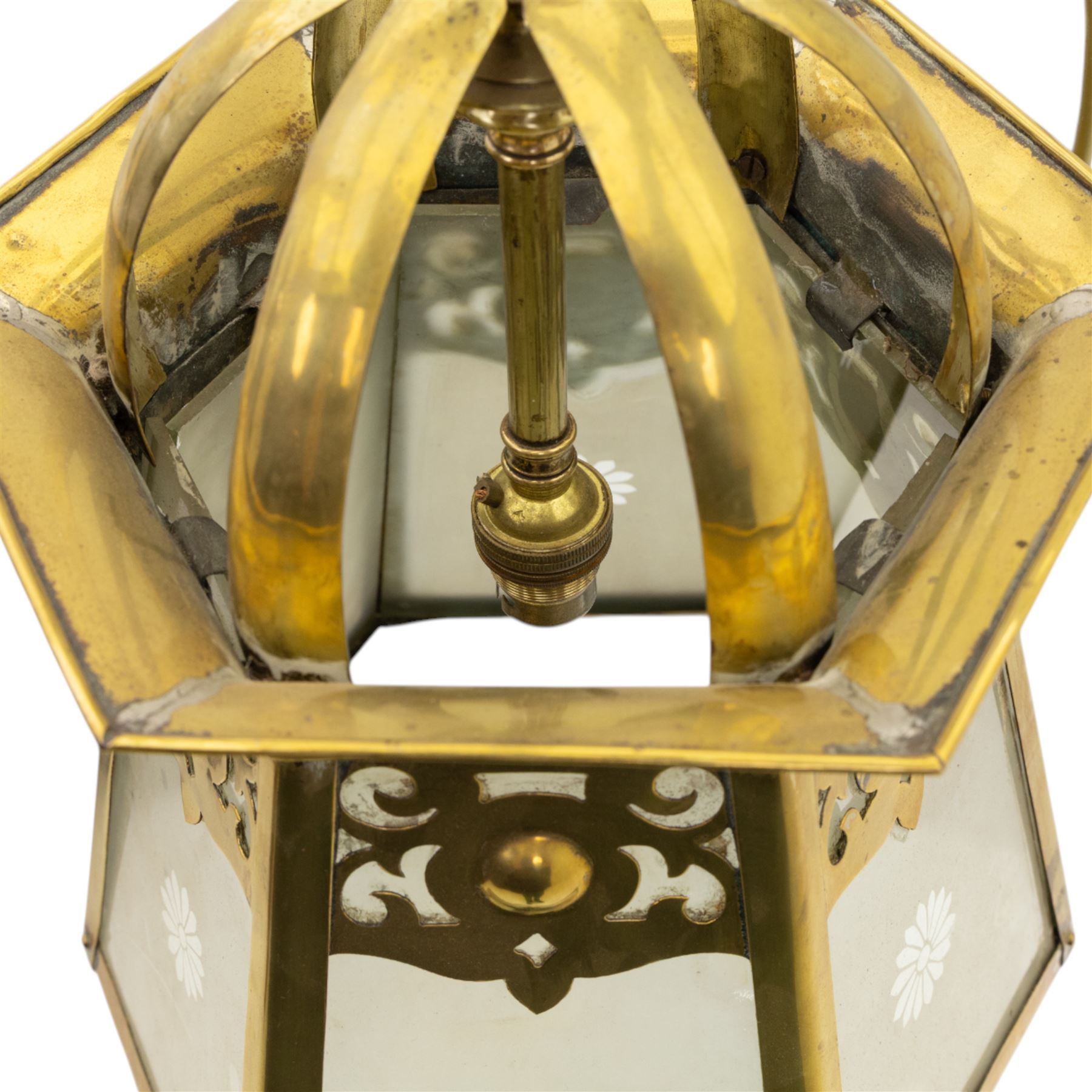 Arts & Crafts brass hall lantern, circa 1900, of hexagonal tapering form with open dome top support and pierced foliate detail above frosted glass panels with flower head detail, H41.5cm D29cm