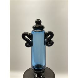 Contemporary glass fly/wasp trap by Gillies Jones of Rosedale, the catcher of bottle form with an ombre design of blue to clear supported by three black ball feet, and a large blue and black stopper with twin scroll handles and finial, signed Gillies 1997 to base, H45cm