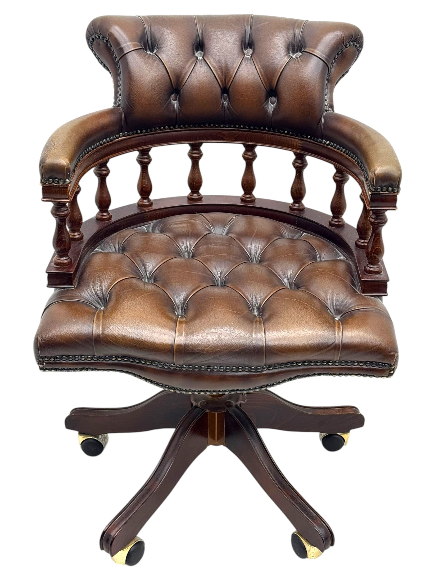 Mahogany framed swivel Captains desk chair, upholstered in brown buttoned leather, turned supports and swivel base on castors