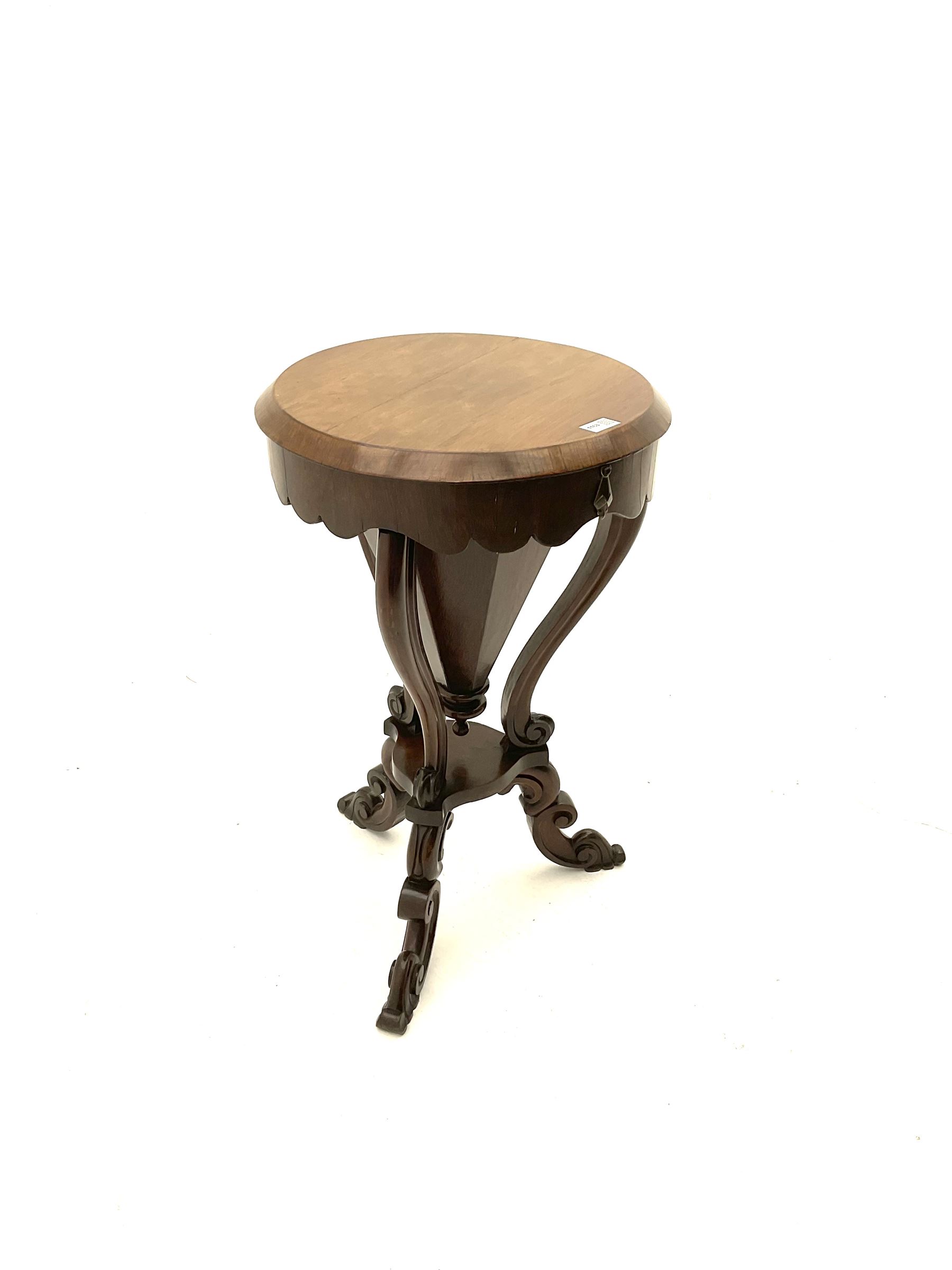 Victorian rosewood work table, circular hinged lid enclosing trumpet shaped body with fitted interior, scroll carved serpentine supports, on tripod base
