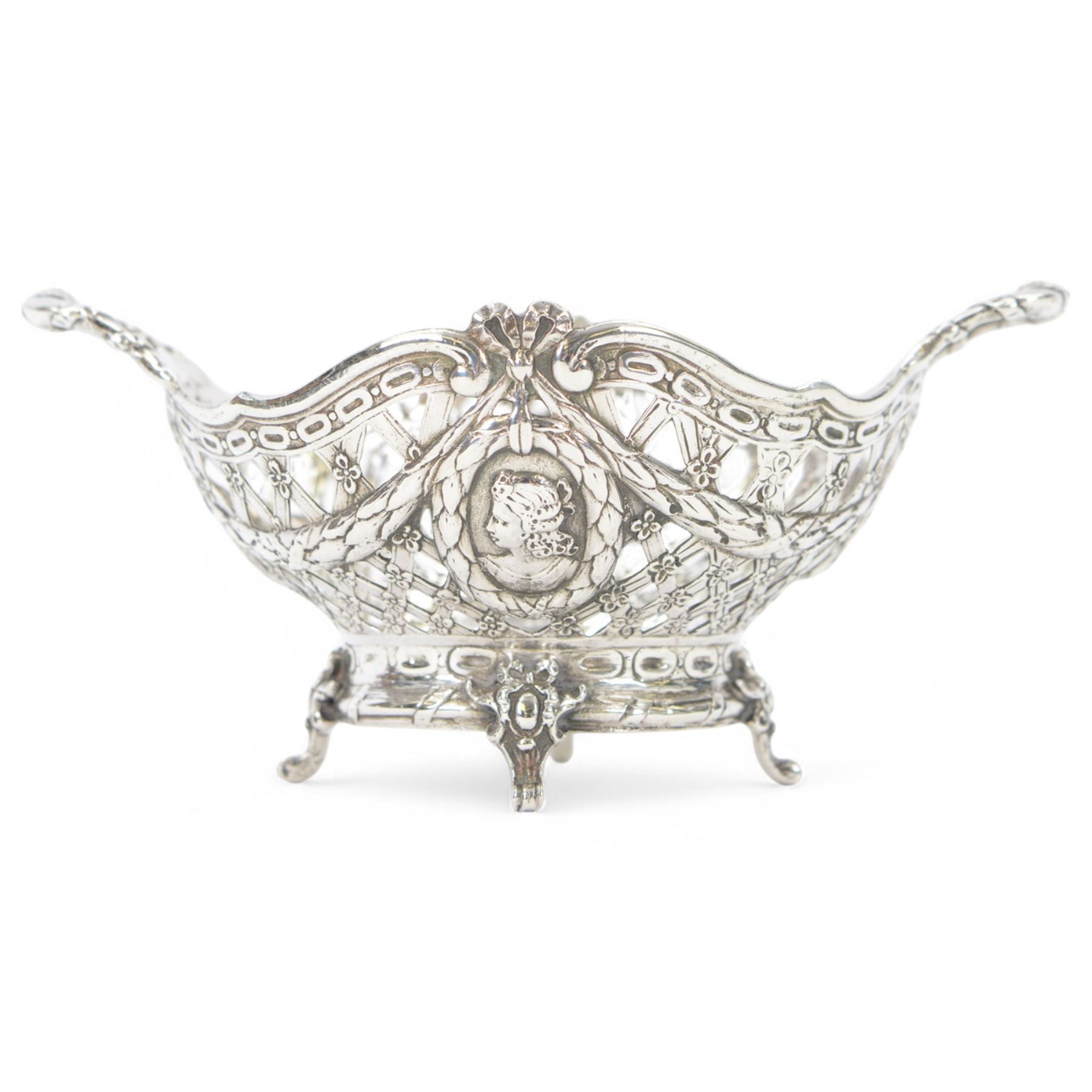 Late 19th/early 20th century German Hanau silver basket, modelled in George II style, of shaped openwork lattice form with twin handles, the body decorated with two portrait roundels and husk and ribbon swags, upon four scroll feet, with unattributed pseudo Hanau marks, and hallmarked John George Piddington, London import 1901, including handles H7cm W15cm
