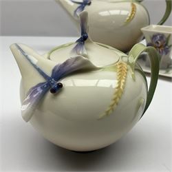 Franz Teapot decorated with dragonflies, together with a matching sucrier and cover and a cup and saucer in Iris pattern, all with printed mark beneath 