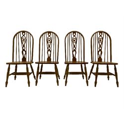 Set of six lightwood Windsor style dining chairs, hoop and stick backs with pierced wheel splats, turned supports joined by H stretchers, two carvers and four side chairs