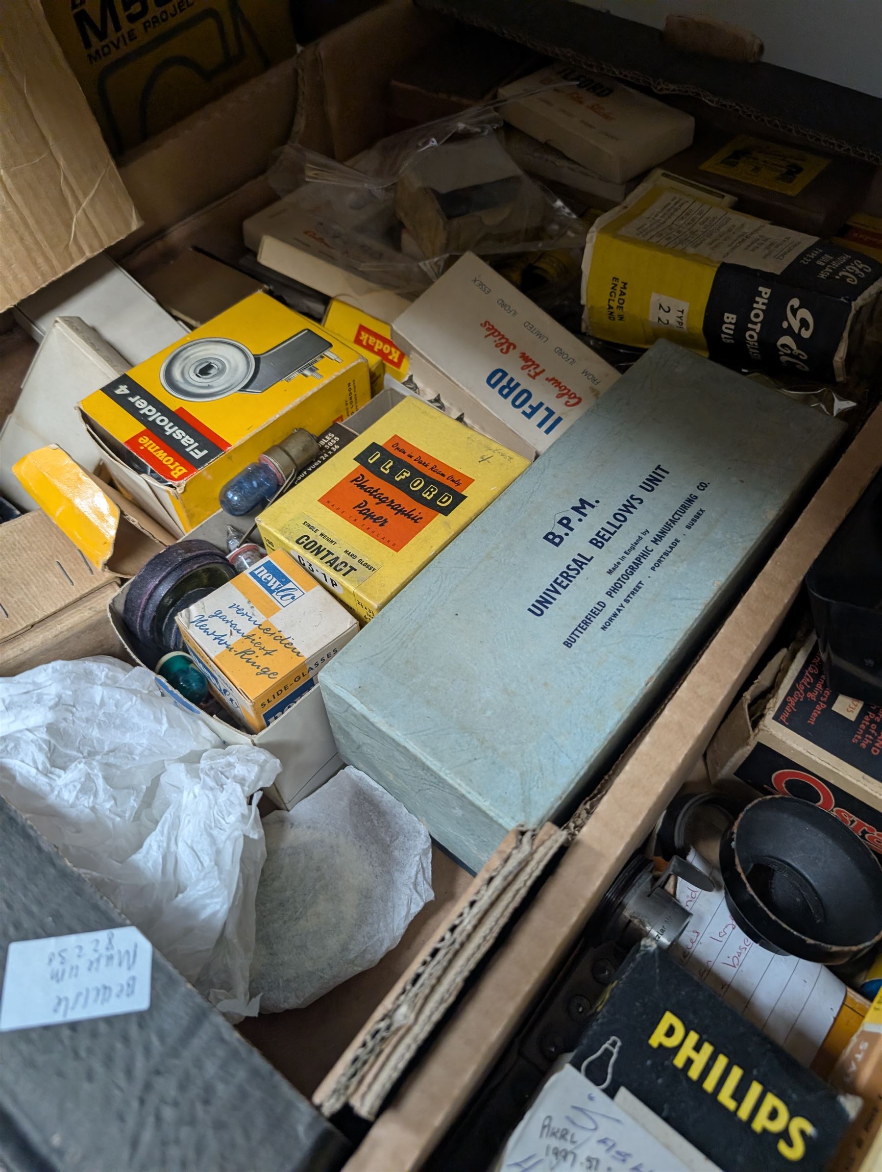 Collection of photography and photograph development accessories, including bulbs, development tanks, trays, projector lenses, etc