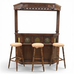 Old Charm - carved oak bar with three bar stools and associated Old Charm drinks cabinet, carved top with channels for glassware beneath, bar surface above glazed panels, shelves for glassware to the back, associated Old Charm drinks cabinet with fall front linenfold carving, above twin doors with shelved interior