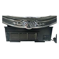 Stained glass and cast iron electric fireplace, arched top with decorative finials, stained glass front panel with floral motifs, flanked by cast iron scrolls, raised on scroll supports