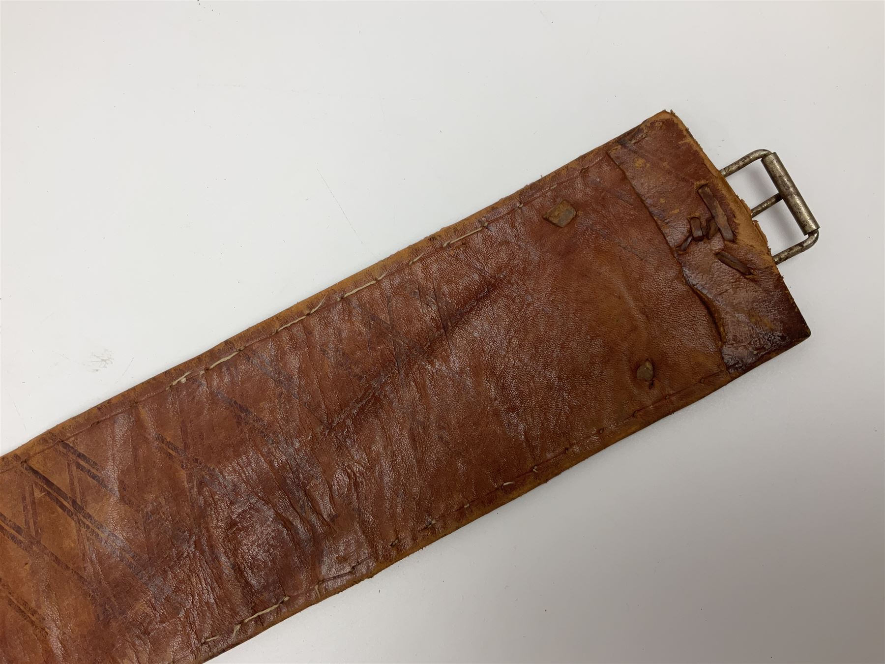 Late 19th century Yemeni Tuza jambiya as worn by religious elite, the 20.5cm curving blade with raised medial ridge, the horn hilt with pique style studwork, in a leather wrapped wooden scabbard with pierced metal mount and leather belt applied with embroidered 'gold' and 'silver' thread work panel; dagger L36cm overall, belt L84cm