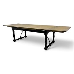 Barker & Stonehouse - large oak extending draw-leaf dining table, rectangular plank top over a black painted base, turned supports joined by shaped stretchers, extending at each end with pull-out leaves