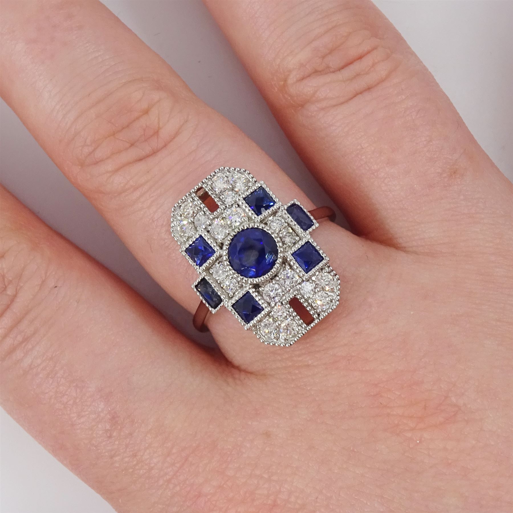 Platinum sapphire and diamond panel ring, milgrain set with round and calibre cut sapphires and round cut diamonds, stamped Pt 950, total sapphire weight 0.87 carat, total diamond weight 0.46 carat