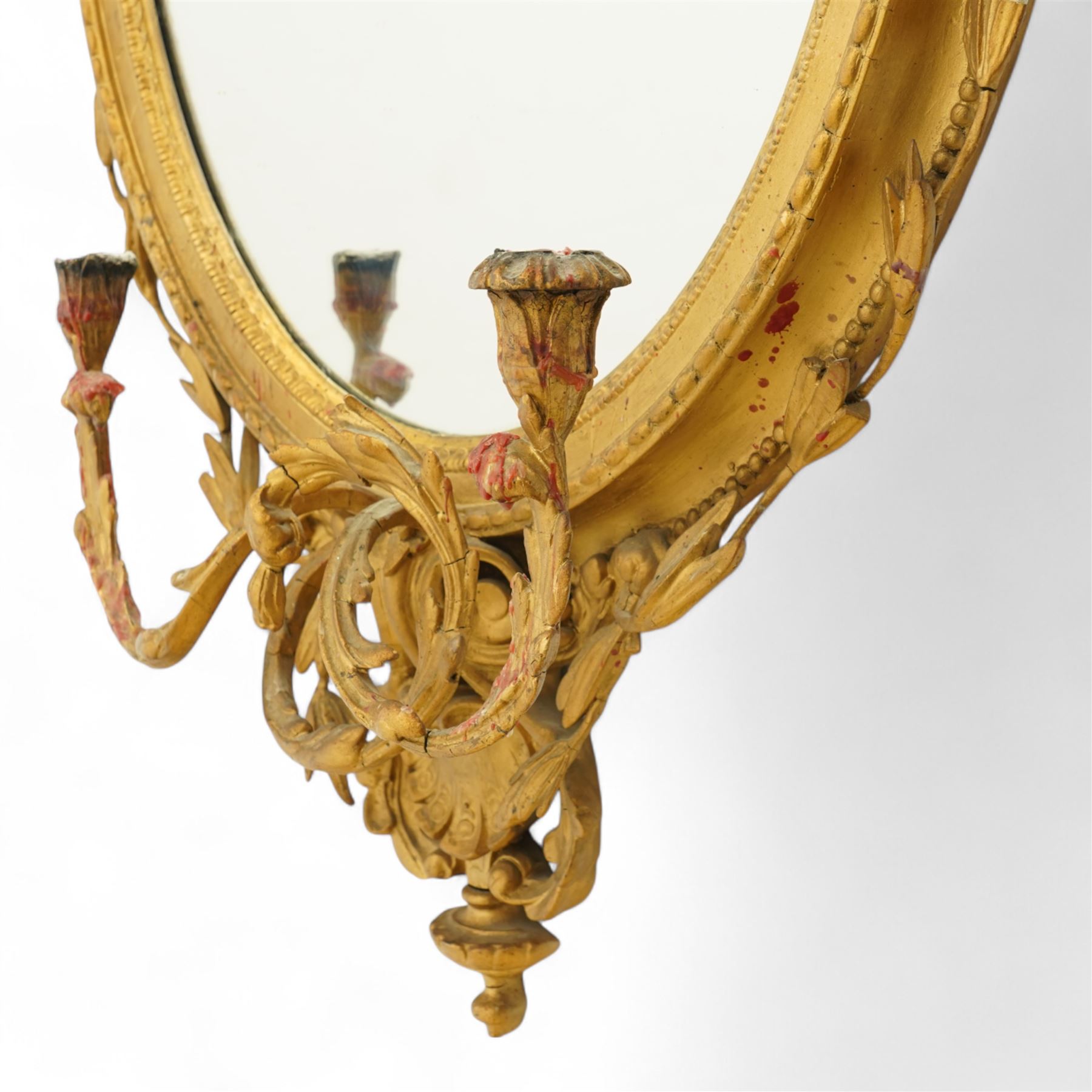 Late 19th century Louis XVI style giltwood and gesso girandole oval wall mirror, the oval frame surmounted with stylized urn finial and ribbon-tied garlands, laurel swags and rosettes, egg and dart decorated inner moulding and linked acorn outer moulding, flanked by intertwined foliate decorated candle branches 