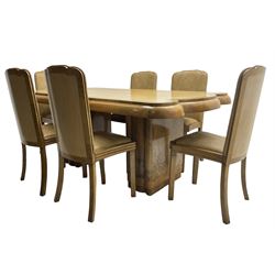 Early 20th century Art Deco walnut twin pedestal dining table, shaped top with thick crossbanding over a rounded edge, raised on two shaped pedestals (W187cm D107cm H76cm); and set of six matching dining chairs, the high back and sprung drop-in seat upholstered in walnut effect faux leather with reeded apron, raised on square supports (W47cm H97cm)