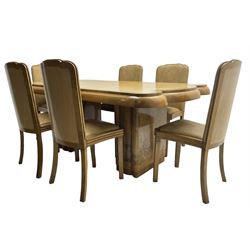  Early 20th century Art Deco walnut twin pedestal dining table, shaped top with thick crossbanding over a rounded edge, raised on two shaped pedestals (W187cm D107cm H76cm); and set of six matching dining chairs, the high back and sprung drop-in seat upholstered in walnut effect faux leather with reeded apron, raised on square supports (W47cm H97cm)