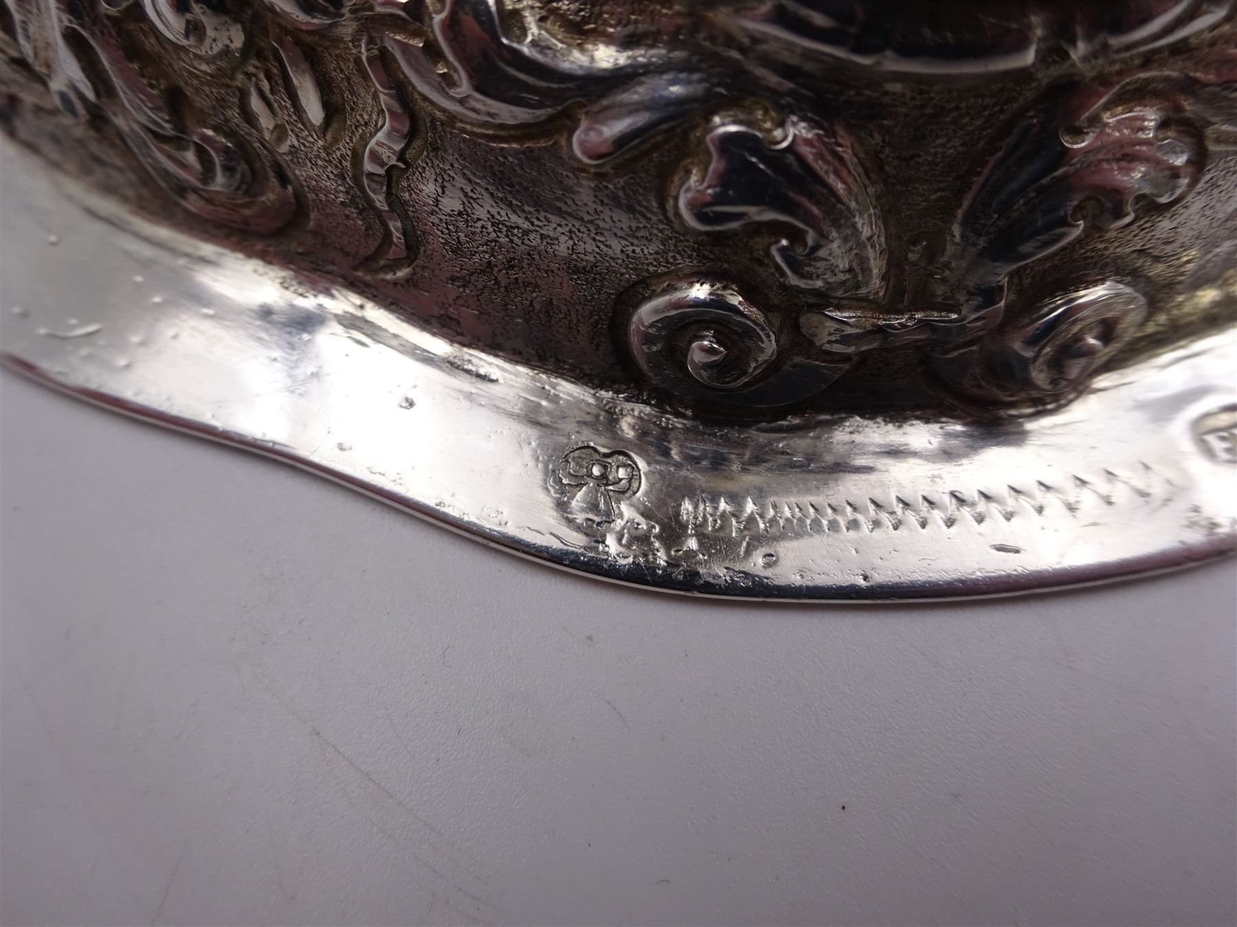 German silver chalice, the bowl, stem and foot each with 19th century repousse and chased decoration depicting putti masks, C scrolls and flowers, set with two hand painted porcelain roundels, possibly Berlin, and six later applied enamel roundels, each depicting religious scenes, the gilded bowl upon knopped stem and spreading octofoil foot, the base with marks for Munich, c.1695 and maker's mark FK