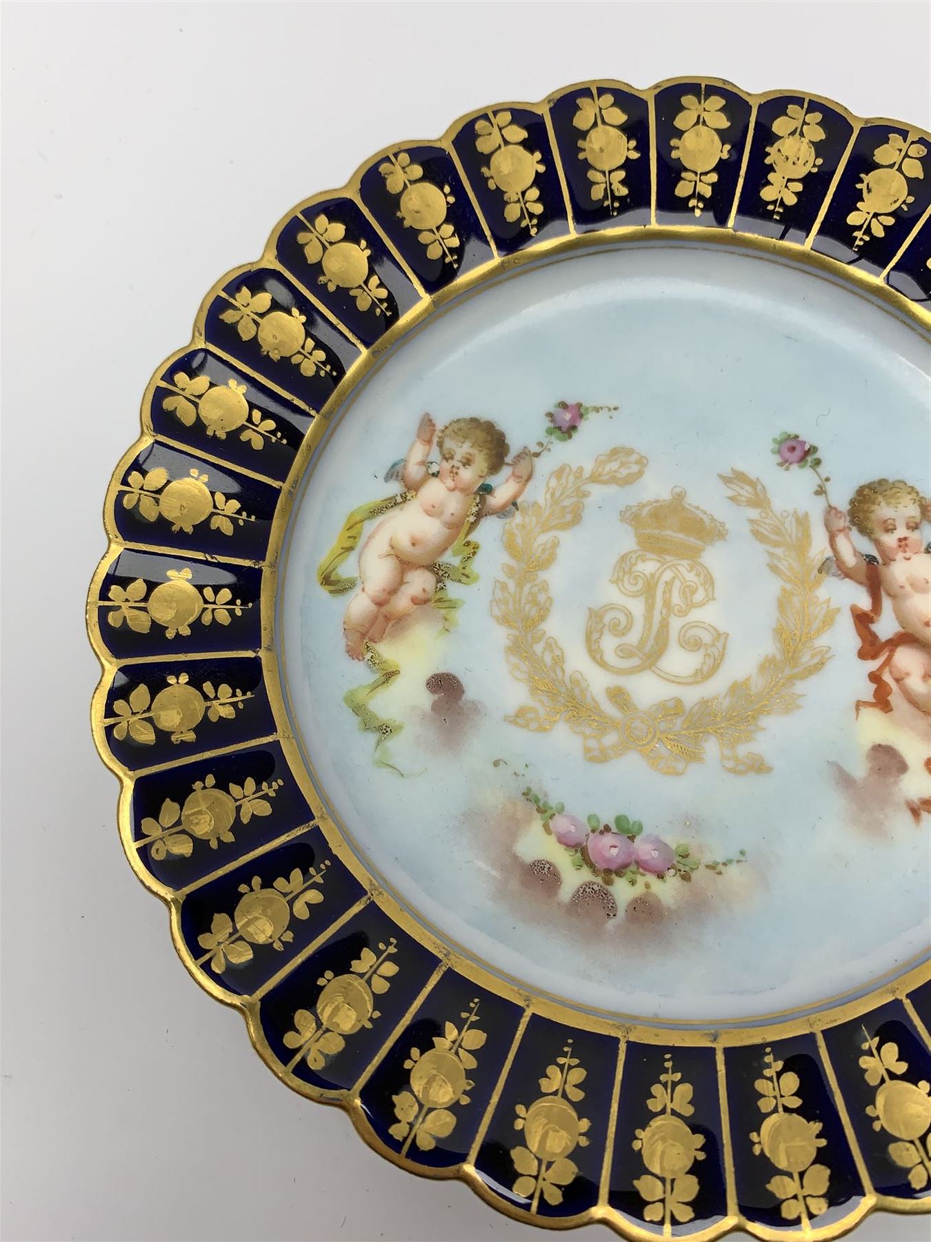 Mid 19th century Sevres Louis Philippe period porcelain cabinet plate, decorated with central Louis Philippe crowned monogram flanked by two cherubs, within cobalt gilt detailed border, with date mark for 1846, red inventory mark for Chateau des Tuileries, and blue monogram mark , D14.5cm
