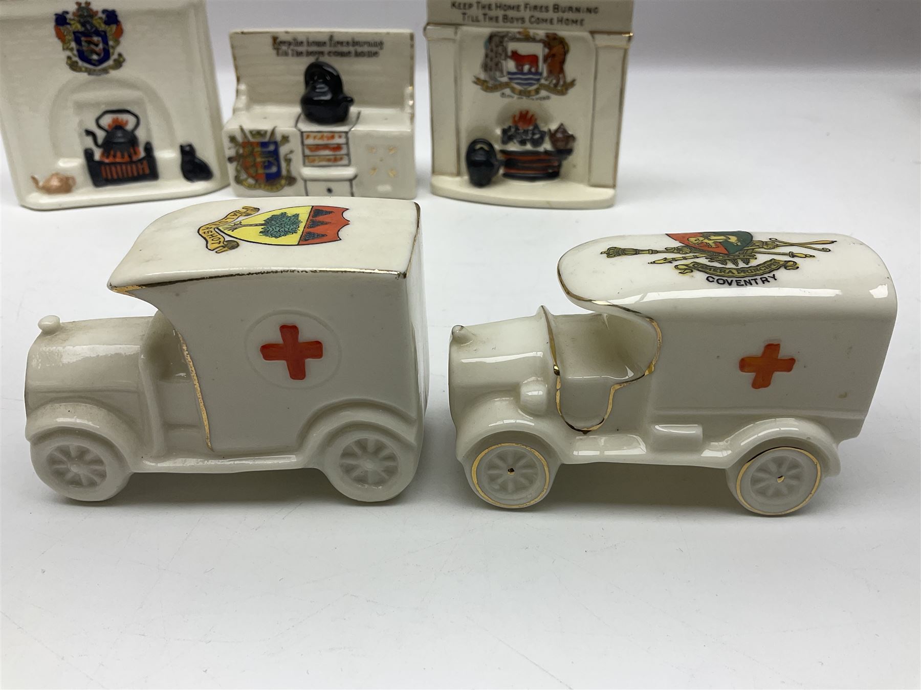 Ten WW1 crested china military models comprising seven field ambulances and three 'Home Fires Burning' fire-surrounds/range; various makers including Willow Art, Arcadian China, Grafton China, Savoy China, Carlton China etc; various crests including Devon, Aldershot, Portsmouth, West Ham, Coventry, Oxford, Hastings, Brighton etc (10)