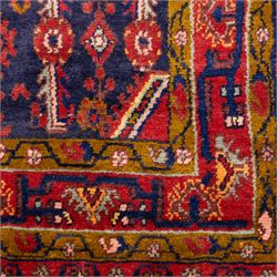 North West Persian Cirjan hand-knotted rug, indigo field decorated with vertical columns of stylized boteh, rosettes and diamond devices arranged in a repeating lattice and a chain of linked lozenges, enclosed by a mustard gold inner border and a principal border of madder ground, flanked by narrow guard stripes, with cotton fringe ends 