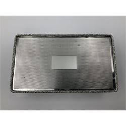 1920's silver table cigarette box, of rectangular form with engine turned decoration to the exterior, the hinged cover with central vacant rectangular panel and raised foliate rim, opening to reveal a gilt interior with later plush lining, hallmarked Charles Henry Dumenil, London 1923, H3.5cm L14.5cm D8.5cm