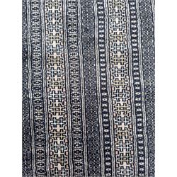 Large Persian Bokhara wool rug, the field decorated with repeating gul motifs in lozenge medallions across a dark ground, enclosed by multiple geometric borders in indigo, ivory and terracotta, from the region of Baluchistan
