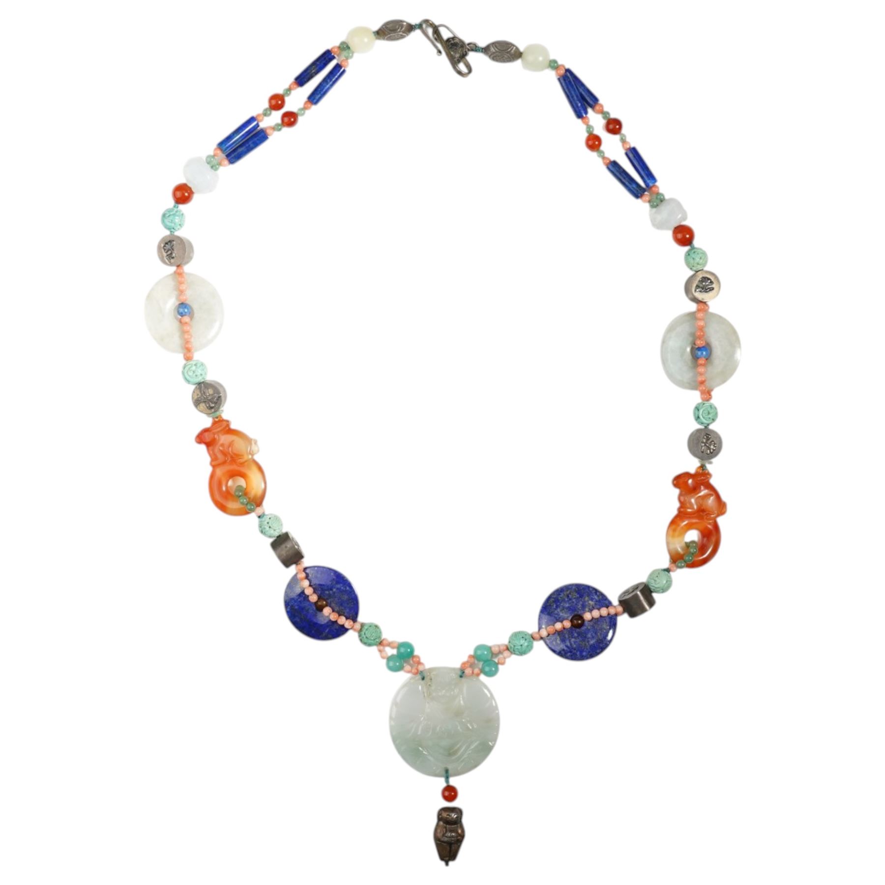 Chinese stone set necklace, with carved buddha disc, carved agate rabbits, lapis lazuli bi disc beads, coral and other hardstone beads