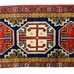 Small Persian indigo ground rug or mat, the field decorated with three geometric medallions, the border decorated with repeating flower heads