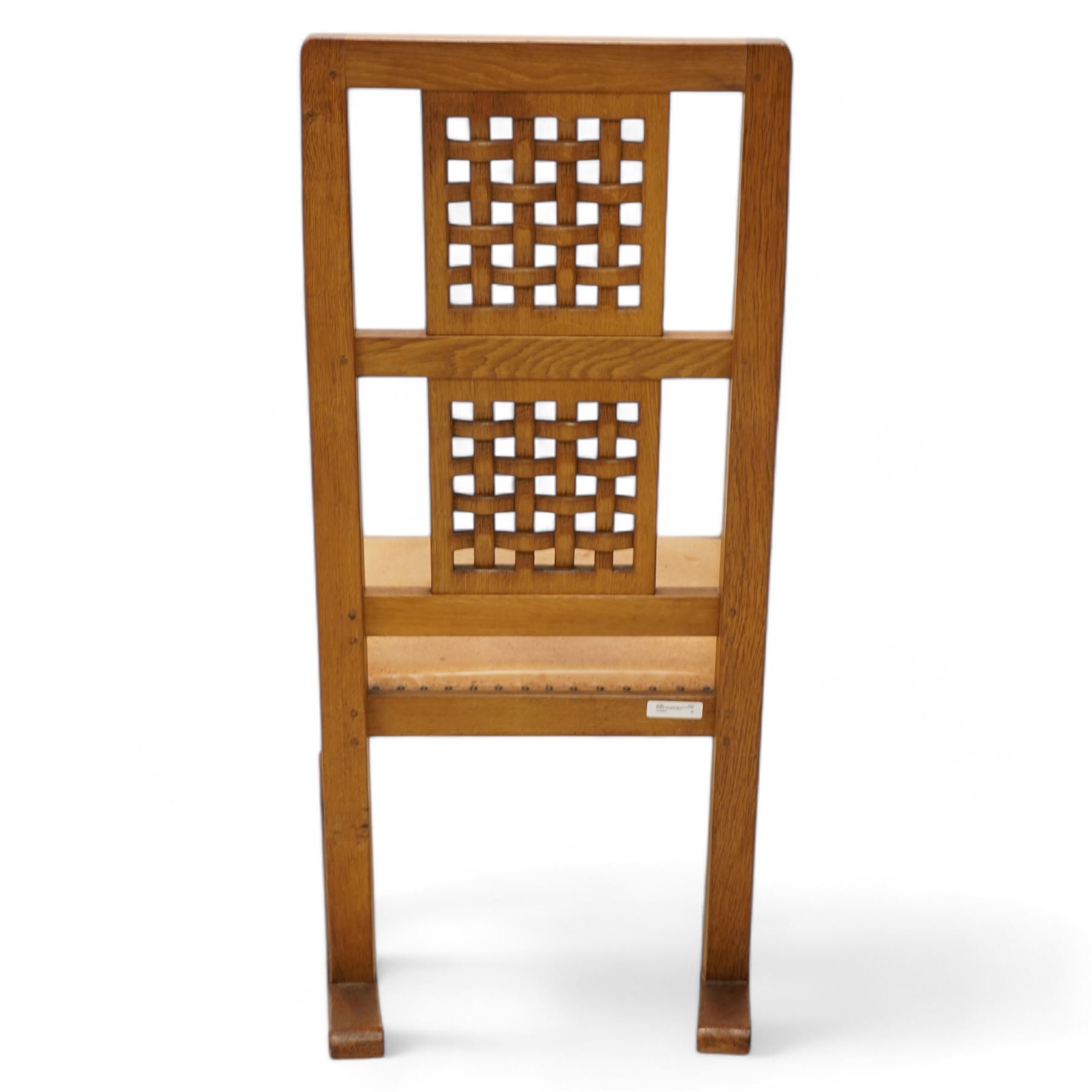 Mouseman - oak rocking armchair, double pierced and carved high lattice back, upholstered in tan leather with stud work, raised on octagonal front supports, carved with mouse signature, by the workshop of Robert Thompson, Kilburn

Provenance - this lot comes to us for sale from direct descent of Robert Thompson. Thompson is the great grandfather of the vendor.