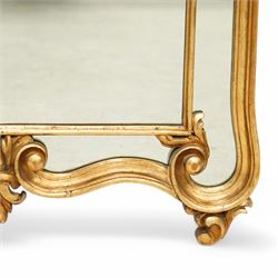 Rococo design carved gilt wood wall mirror, shaped and moulded frame decorated with scrolling leafage, plain mirror plate divided by mouldings