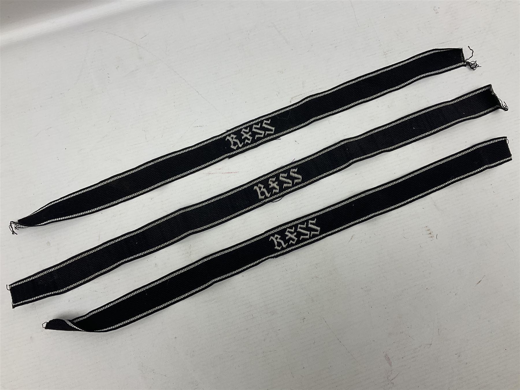 Three Reichsfuhrer 'SS' cuff titles; RZM 'SS' paper tag; German Water Police belt buckle; Destroyers badge marked RKS verso; N.S.B.O. lapel badge; and incomplete party eagle cap badge (8)