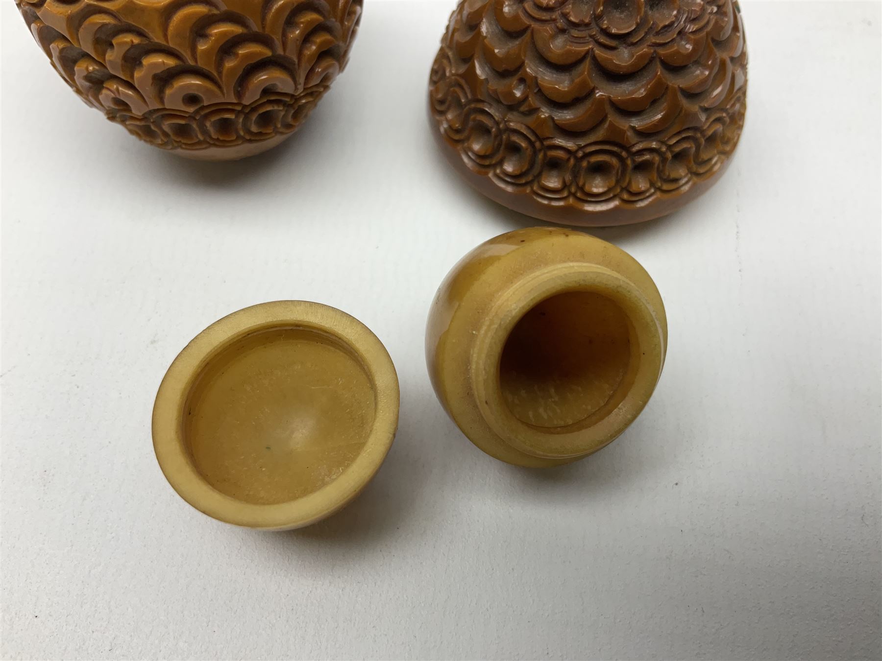 Three 19th century coquilla nut pomanders or flea catchers, each of egg shaped form with carved and pierced decoration and screw threaded join, largest example 6cm