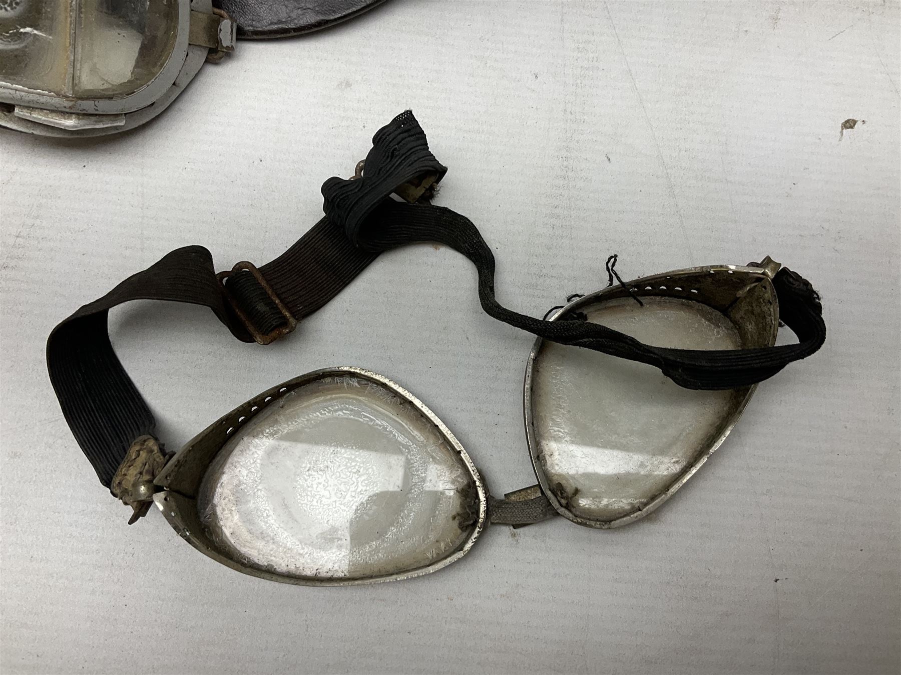 Two Geno Paris small size motorcycle helmets; and three pairs of goggles, one marked 'Stadium'