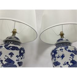 Pair of table lamps of baluster form, decorated with decorated with dragons chasing flaming pearls amongst clouds, on circular footed base, including shades H61cm