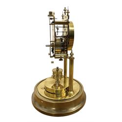 Gustav Becker - German early 20th century torsion clock, with a skeleton movement and rotary oscillating pendulum, enamel dial with Arabic numerals , minute markers and steel spade hands, on a circular brass base with a glass dome, serial No 2173866, with torsion spring complete and in place. With key.
