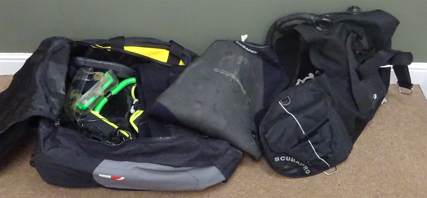 Scuba Diving Equipment including Scubapro Regulator set with gauges and compass, Glide 2000 buoyancy vest, XL wet suit, pair of Mares swim fins, pair of size 9 boots, UK Sunlight D4R searchlight with charger, Uwatec watch, Oceanic knife & scabbard with instruction manuals, Scubapro pouches and an Aqualung wheeled rucksack, (qty) 