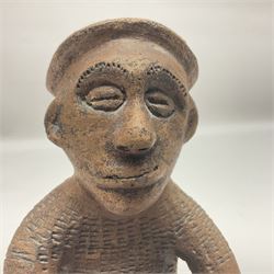 Native naive terracotta figure of a man seated on a stool cradling a bird, H20cm together with a Zulu wedding basket with certificate signed by the weaver (2)