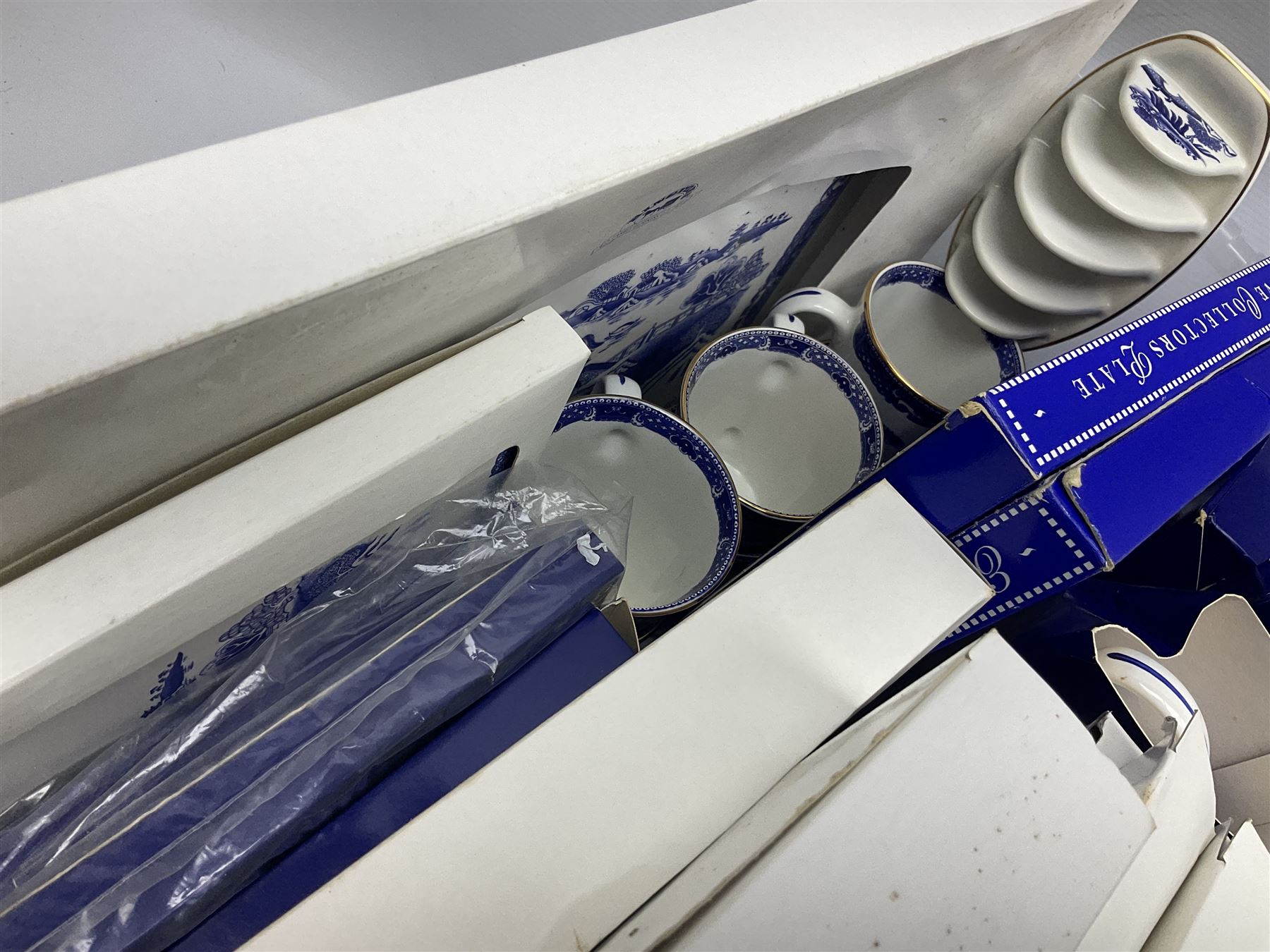 Large quantity of Ringtons blue and white Willow pattern ceramics, to include exclusive collectors examples, dinner plates, teapots, breakfast set, etc, predominantly boxed, four Capodimonte figures comprising example modelled as a girl reading with a puppy, boy giving a bone to a dog, boy reading on cushion and tramp boy sat cross legged with umbrella, together with three The Leonardo Collection figures comprising Midsummer Melody, Alfresco and Butterfly Catchers