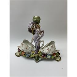 A group of 19th century and later figures and vases, to include a centre piece with female figural stem and base with two vases modelled as swans, a pot modelled as a boy stood upon a balcony, H20cm, a pair of pots modelled as female figures pushing foliate modelled barrows, etc. 
