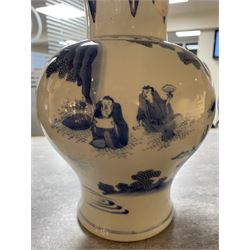 Pair of Chinese Kangxi blue and white porcelain vases, each of baluster form, painted with an outdoor scene containing figures seated upon the ground reading scrolls and holding fans, willow and bamboo tress, rock work and water, H27cm