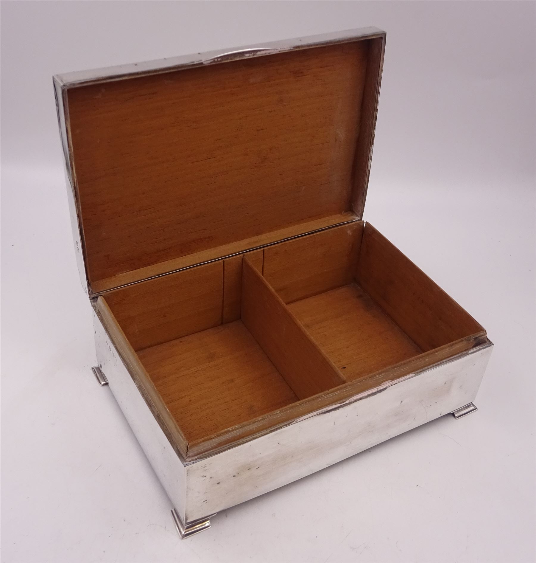 1920s silver mounted presentation cigarette box, of rectangular form, with engraved initials J.W.J and dated 1902-1927 to slightly domed hinged cover, opening to reveal compartmentalised softwood interior, upon four bracket feet, hallmarked Birmingham 1920, maker's mark worn and indistinct, H9cm, W23cm, reputedly given to John William Johnson, father of Amy Johnson,  famous for being the first long distance (to Australia) solo female pilot, and first female British grounds engineer, for his silver wedding anniversary