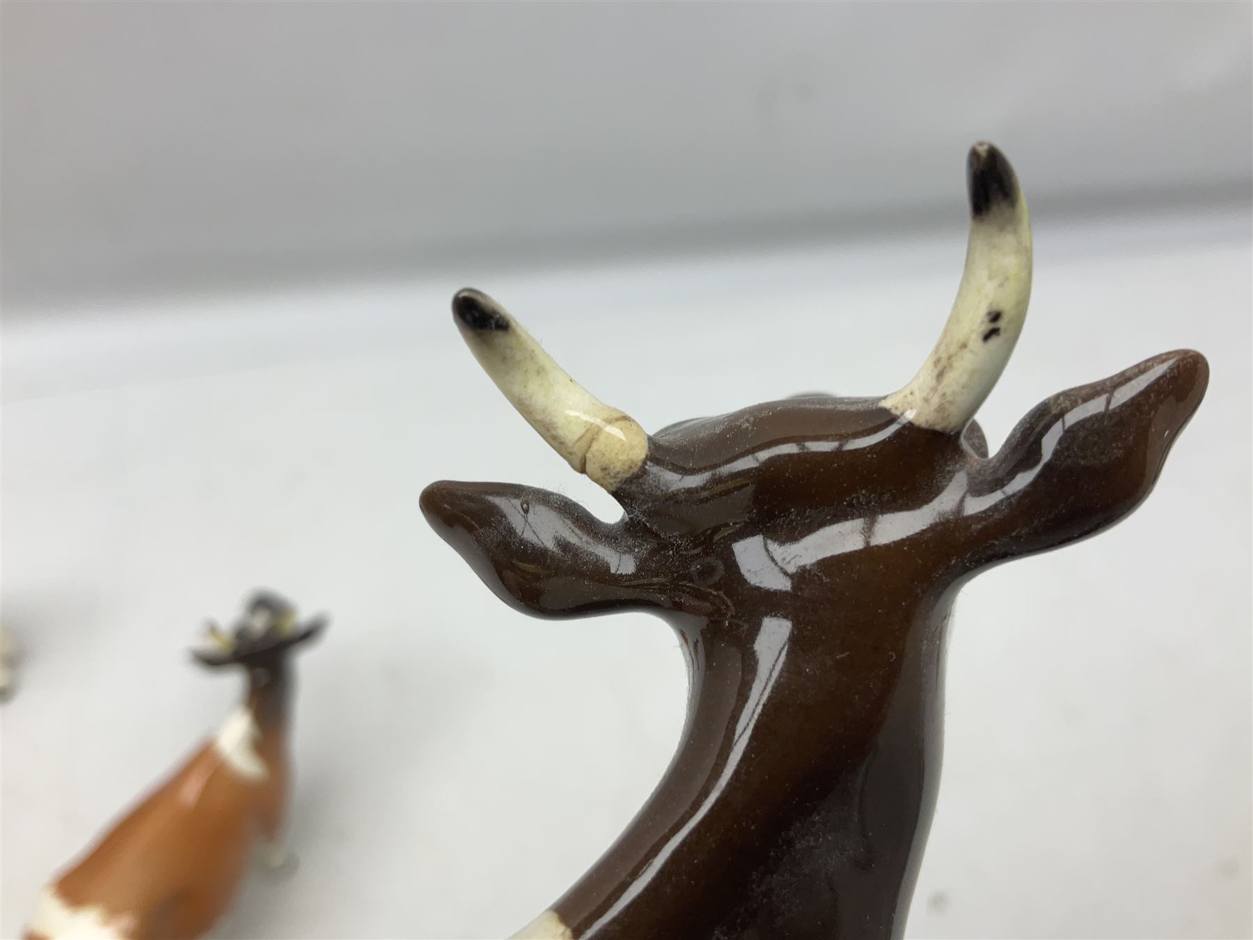 Five Beswick figures of cattle Comprising Ayrshire Bull Ch Whitehill Mandate, no 1454B, three Ayrshire Cow Ch Ickham Bessie, no 1350 and Ayrshire Calf, no 1249B, all with printed marks beneath