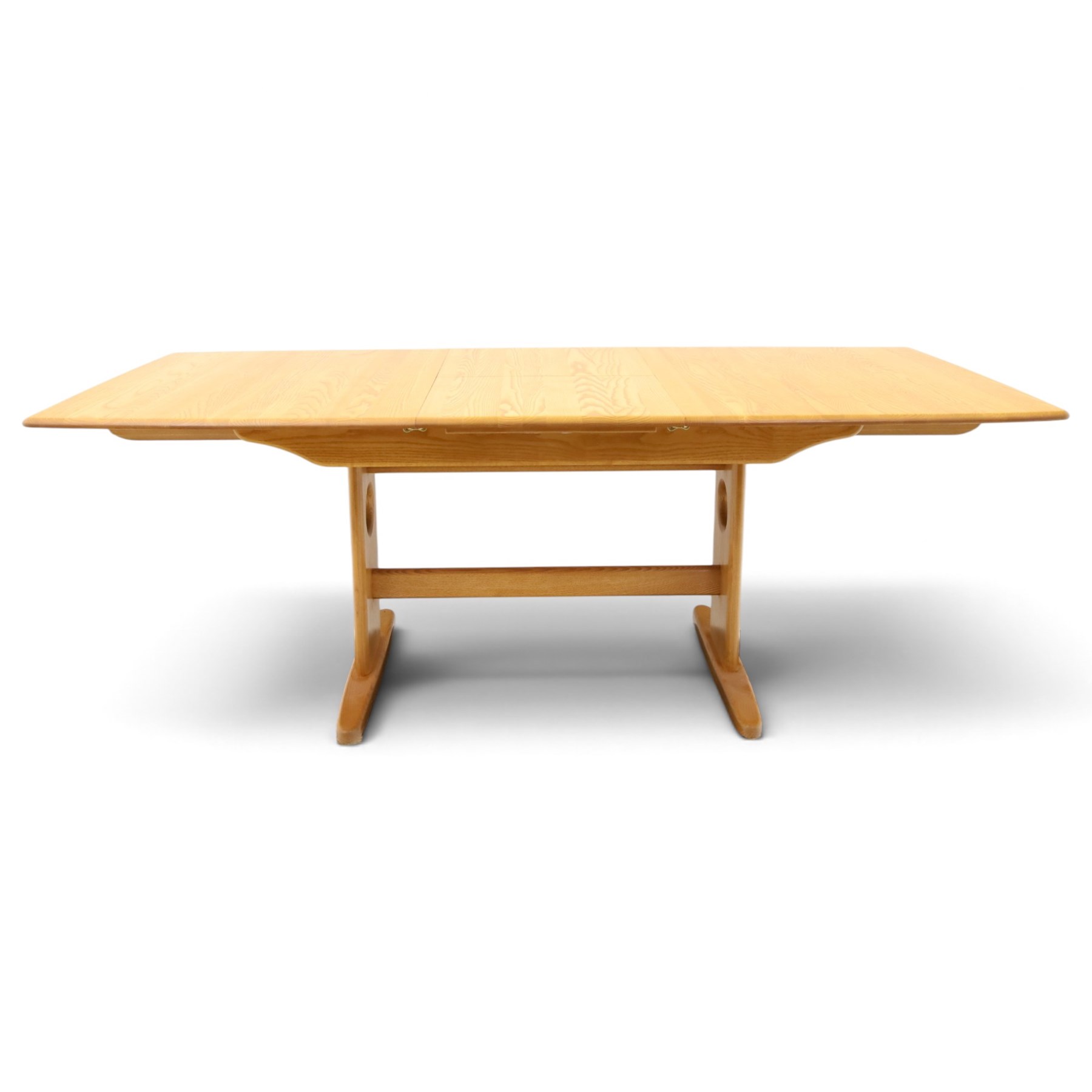 Ercol - 'Windsor' ash medium extending dining table, with stowed fold over leaf extending to 200cm, shaped supports with roundel aperture, united by a stretcher