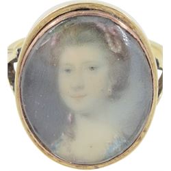 19th century gold portrait ring, set with an oval miniature of a woman wearing a pearl hairpin and earrings on ivory, under a glazed panel, set into a later gold ring with split shoulders. This lot has been registered for sale under Section 10 of the APHA Ivory Act