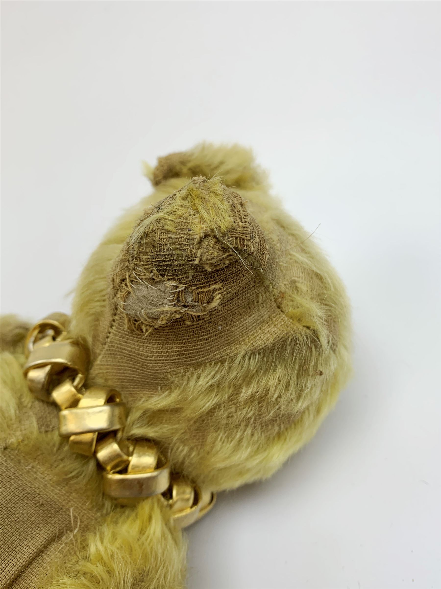 Early 20th century English teddy bear, with wood wool filled body with jointed limbs, felt covered paw pads, five claw stitching to feet and elongated arms with spoon shaped paws H14