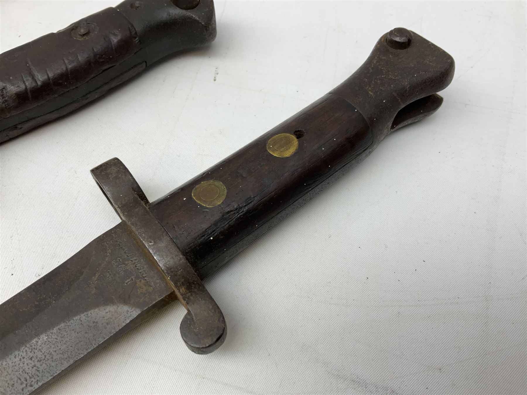 British Pattern 1907 bayonet with 43.5cm fullered steel blade; in leather scabbard with webbing frog L58cm overall; another Pattern 1907 bayonet lacking scabbard; and British Pattern 1888 Mk.I bayonet by Wilkinson London (no scabbard) (3)