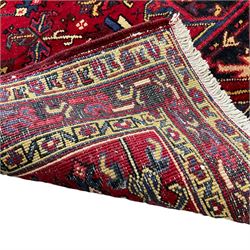 Persian Hamadan red ground rug, decorated with stylised plant motifs, the band border with repeating design